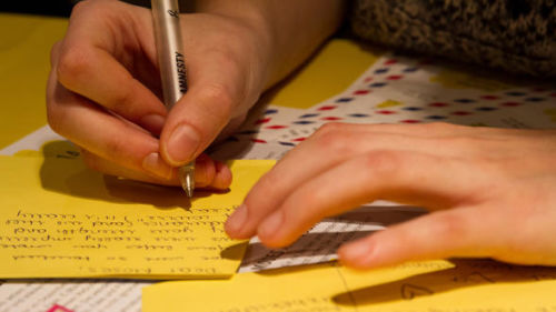Zu sehen sind die Hände einer Person, die einen Brief schreibt. Der Brief ist Teil der Amnesty-Kampagne "Briefe gegen das Vergessen"